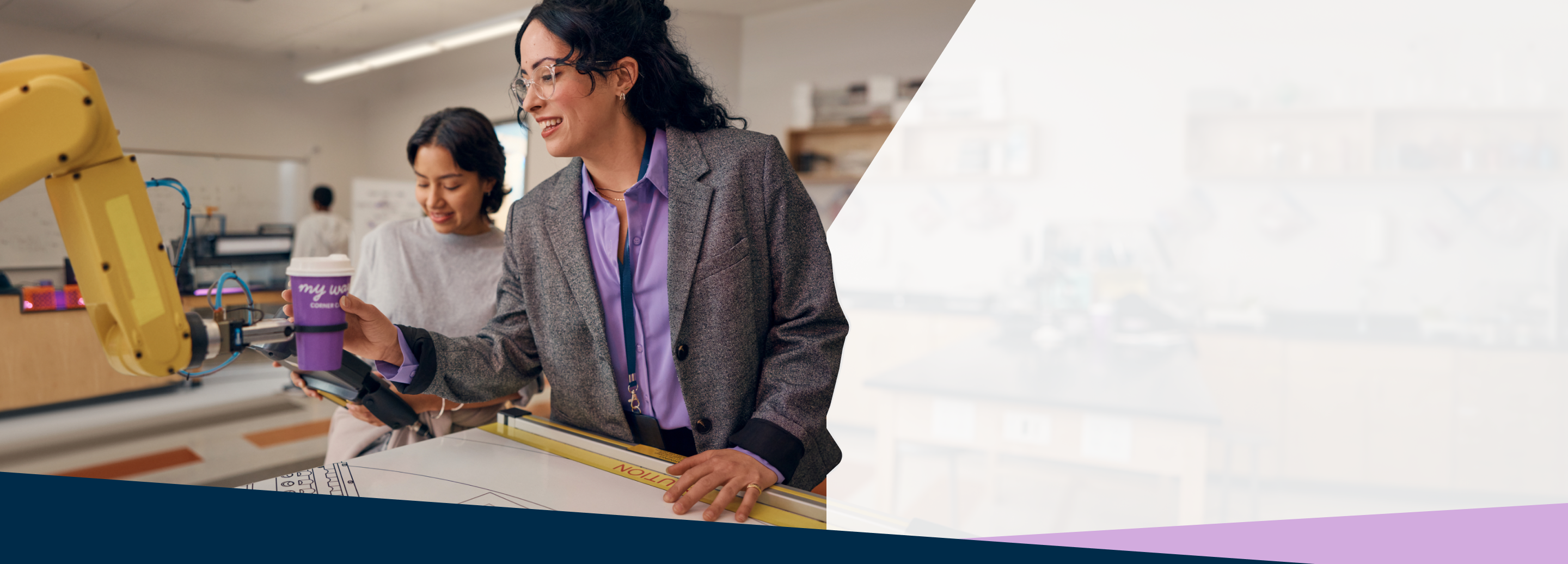 Teacher with student in a robotics lab.