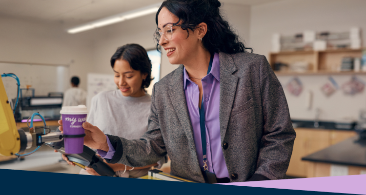 Teacher with student in a robotics lab.