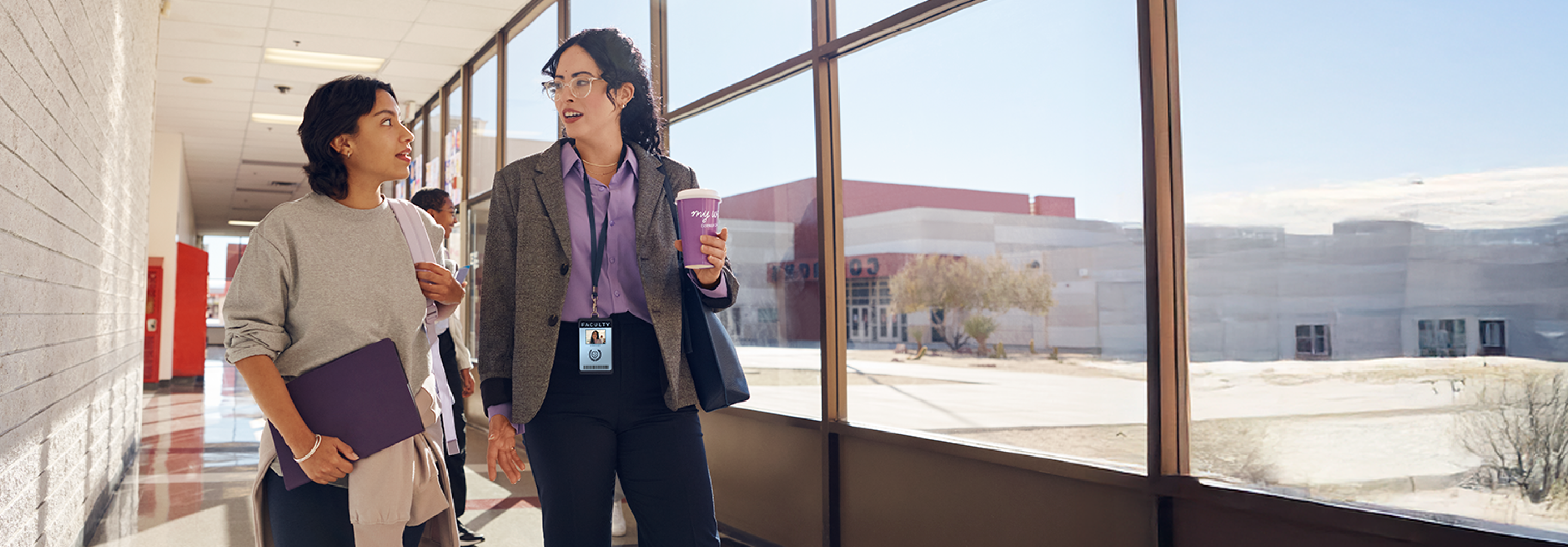 Teacher and student walking together down a hallway.