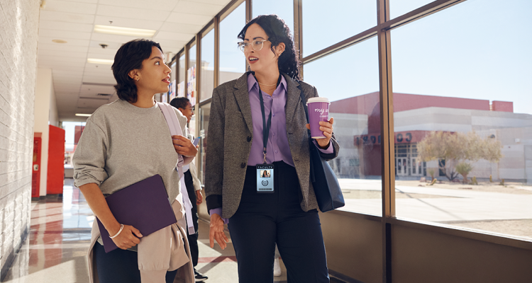 Teacher and student walking together down a hallway.