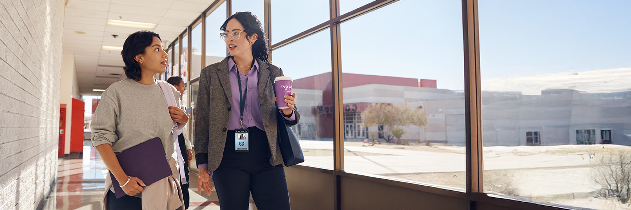 Teacher and student walking together down a hallway.