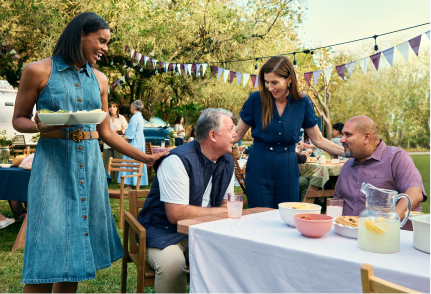 Monica Seles and members of the gMG community talking together at a garden party.