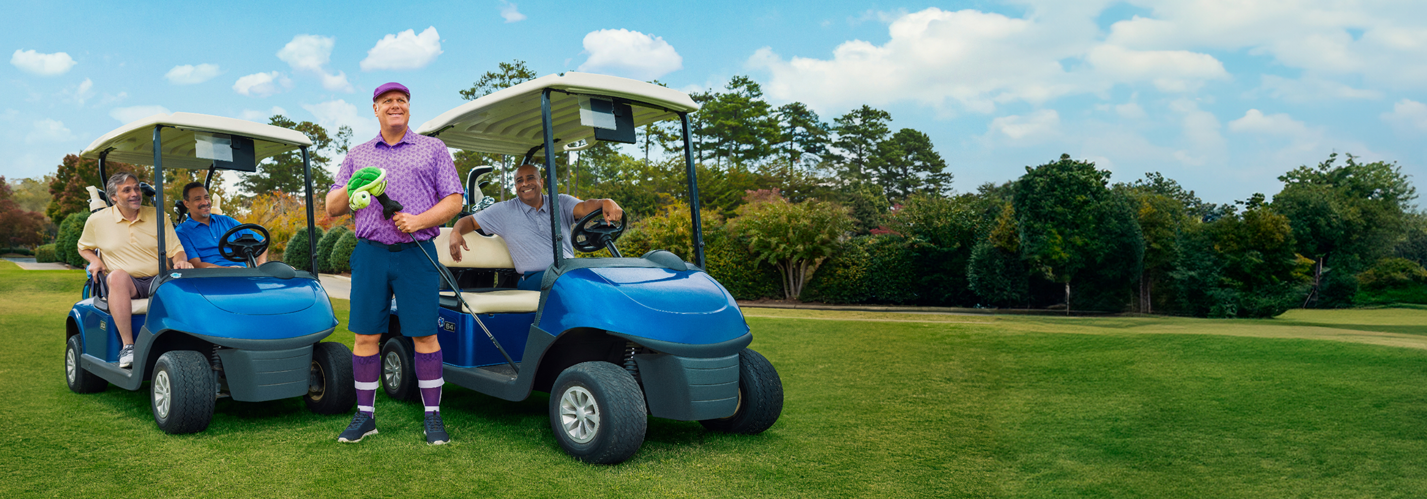 A group of men on the golf course, some in golf carts and one standing