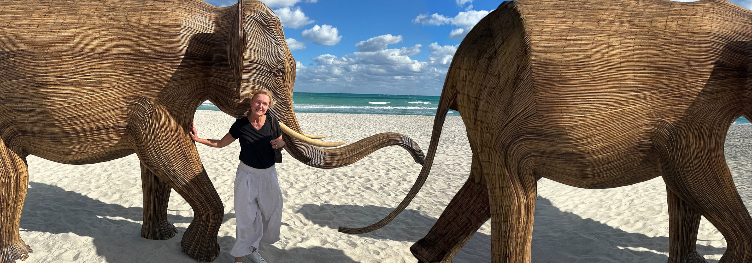 Photo of Kristen standing and smiling on a beach